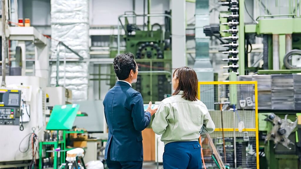 Businessperson and worker inspect factory